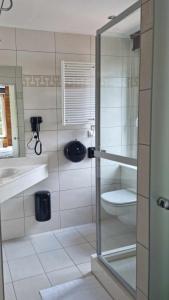 a bathroom with a toilet and a sink and a mirror at Hotel L'ermitage in Houffalize