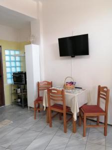 a dining room with a table with chairs and a television at Waterway view in Galatas