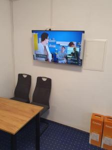 a room with a tv on a wall with a table and chairs at ST3 Apartment in Triberg