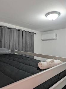 una camera da letto con un grande letto nero con finestra di Family-Home-Workplace-Peace a Arecibo