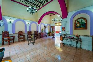 Habitación grande con paredes de color púrpura y blanco y vestíbulo. en Hotel San Juan Mérida en Mérida