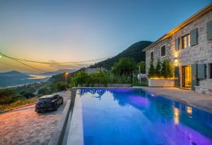 a car parked next to a house with a swimming pool at Villa Di Campagna in Kotor