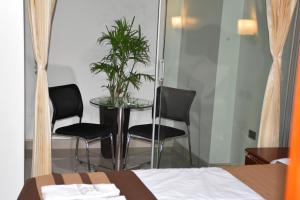 a room with two chairs and a table with a plant at Hotel el palacio in Huancayo
