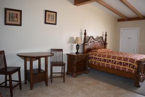 a bedroom with a bed and a table and chairs at BUTTERFIELD STAGE MOTEL in Deming