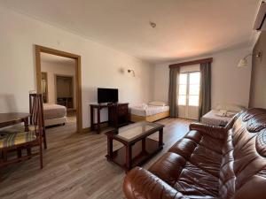 a living room with a leather couch and a table at Hotel O Gato - Edificio Standard in Odivelas