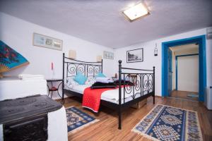 1 dormitorio con cama negra y manta roja en Pensiunea La Gura Portitei - Jurilovca en Jurilovca