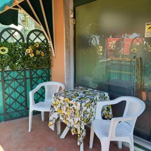 einen Tisch und Stühle auf einer Terrasse in der Unterkunft Appartamento fronte spiaggia in Cavi di Lavagna
