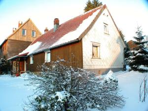 une maison avec de la neige devant elle dans l'établissement Haus-Hohegeiss-freistehend-und-zentrumsnah, à Hohegeiss