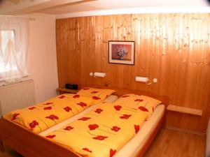 a bedroom with two beds with red flowers on them at Haus-Hohegeiss-freistehend-und-zentrumsnah in Hohegeiß