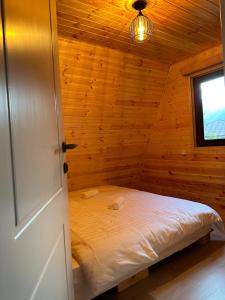 1 dormitorio con 1 cama en una cabaña de madera en Glacier Shoda, en Ghebi
