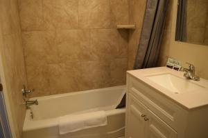 a bathroom with a sink and a bath tub and a sink at BUTTERFIELD STAGE MOTEL in Deming