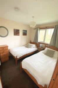 - une chambre avec 2 lits et une fenêtre dans l'établissement Detached Bungalow in North Cornwall, à Bodmin