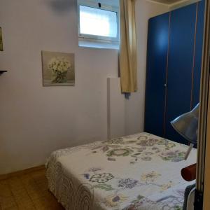 een kleine slaapkamer met een bed en een raam bij Appartamento fronte spiaggia in Cavi di Lavagna