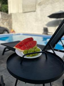 a plate of watermelon and grapes on a table at Vila Hana in Stolac