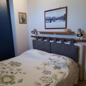 - une chambre avec un lit et une photo sur le mur dans l'établissement Appartamento fronte spiaggia, à Cavi di Lavagna