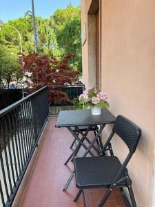 einen Tisch und zwei Stühle auf einem Balkon mit Blumen in der Unterkunft Il Giardinetto in Verona