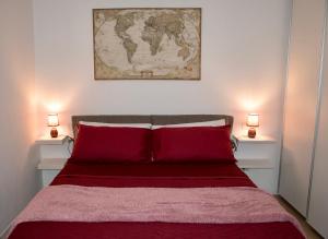 ein Schlafzimmer mit einem Bett mit roter Bettwäsche und zwei Lampen in der Unterkunft Il Giardinetto in Verona