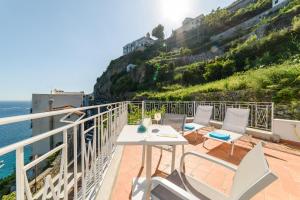 een balkon met een tafel en stoelen en uitzicht op de oceaan bij Eden sul Mare in Amalfi