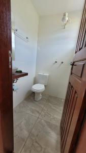 a white bathroom with a toilet and a sink at Hospedagem Cachoeira do Tabuleiro in Cachoeira do Tabuleiro