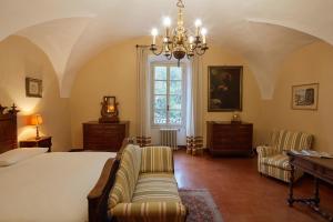 ein Schlafzimmer mit einem Bett, einem Sofa und einem Fenster in der Unterkunft Villa Milesi in Franciacorta in Erbusco