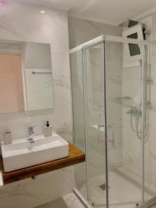biała łazienka z umywalką i prysznicem w obiekcie Lýria Boutique Apartments w mieście Ligia