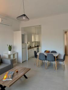 a living room with a table and chairs and a kitchen at Lýria Boutique Apartments in Lygia