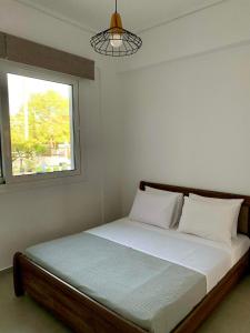 sypialnia z łóżkiem z oknem w obiekcie Lýria Boutique Apartments w mieście Ligia