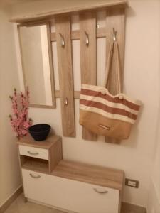 a bathroom with a mirror and a purse on a shelf at Appartamento Casa Margi in Ameglia