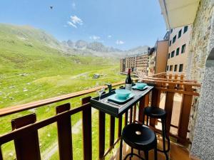 un tavolo con una bottiglia di vino sul balcone di Estudio Pas de la Casa Pie de pista-Vistas-Wiffi-Netfli HUT 7353 a Pas de la Casa