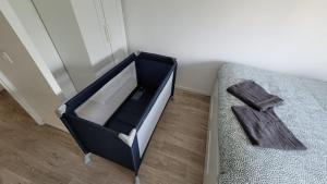 a black and white suitcase sitting next to a bed at Flat for 6 persons 10 minutes from CDG Airport in Le Blanc-Mesnil