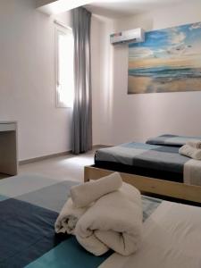 a hotel room with two beds and towels on the floor at Ammare, Casa a Donnalucata in Donnalucata