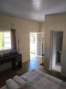 a bedroom with a bed and a door to a bathroom at Pousada Recanto da Mata in Cavalcante