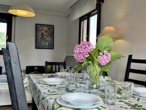 a dining room table with a vase of flowers on it at Las Pozas De Utienes - 7811 in Arnuero