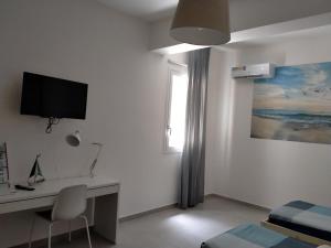 棟納盧卡塔的住宿－Ammare, Casa a Donnalucata，白色的客房设有书桌和窗户。
