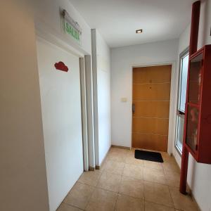 a hallway with a door and a sign on the wall at Luminoso Monoambiente Zona Universitaria 5to piso in La Plata +13 photos
