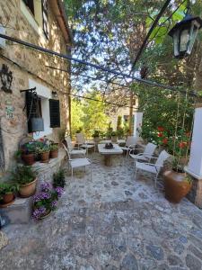 een patio met stoelen, tafels en planten bij Son Niu Vell-La Hermossa in Valldemossa