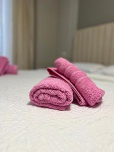 - Toalla rosa sobre la cama en Luxury Apartment in Elbasan, en Elbasan