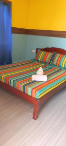 Una cama con una manta colorida y un sombrero. en ALFA Beach Front Lodge en El Nido