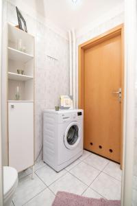 a washing machine in a bathroom with a door at Regem Pokoje Nowogrodzka in Warsaw