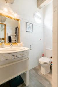 uma casa de banho com um lavatório, um WC e um espelho. em Agréable chambre d'hôtes avec piscine em Le Beausset
