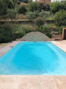 una grande piscina con acqua blu in un cortile di Agréable chambre d'hôtes avec piscine a Le Beausset