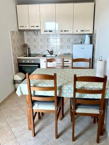 a kitchen with a table with two chairs and a sink at Apartment Kustura in Vinišće