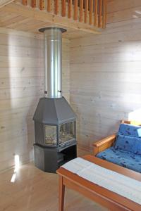 ein Holzofen in einem Zimmer mit einem Bett in der Unterkunft Skatafé in Skata