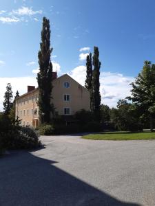 una casa grande con árboles frente a una entrada en Sörgårdens Logi, en Härnösand