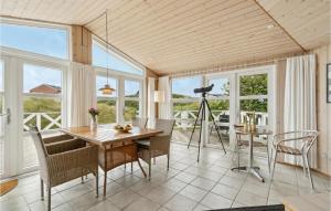 comedor con mesa, sillas y ventanas en Nice Home In Fan With Kitchen, en Fanø