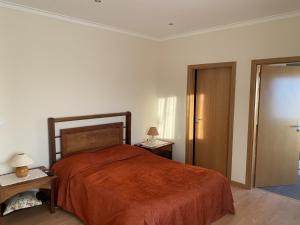 - une chambre avec un lit doté d'un couvre-lit orange dans l'établissement Chez Ilda - Casa da Ilda Alojamento Local, 