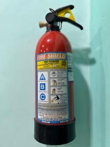 a fire extinguisher is sitting on a table at Teakwood Suite - Nokha House in Kolkata