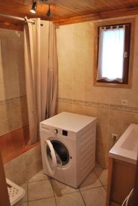 a washing machine in a bathroom with a window at Chalet savoyard By the Rock in Villaroger