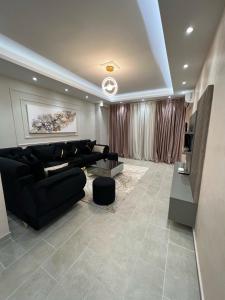 sala de estar con sofá negro y TV en Luxury Apartment in Elbasan, en Elbasan