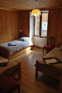 a bedroom with a bed and a chair and a window at Chalet savoyard By the Rock in Villaroger